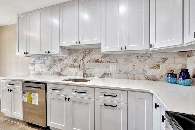 kitchen featuring sink, dishwasher, white cabinets, light stone countertops, and backsplash