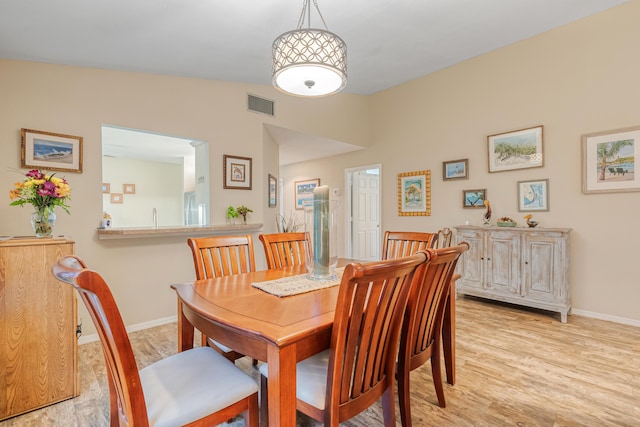 dining room featuring lofted ceiling and light wood-type flooring