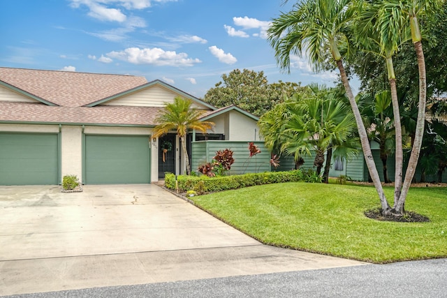 ranch-style house with a garage and a front lawn