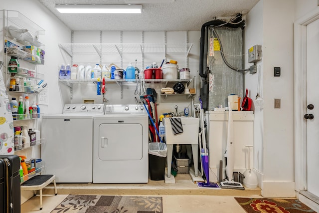 laundry room featuring sink, a textured ceiling, and washer and clothes dryer