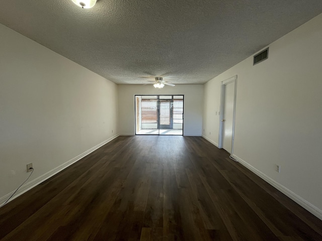 empty room with ceiling fan, dark wood-type flooring, and a textured ceiling