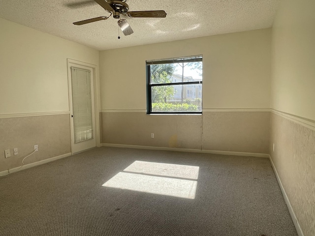 unfurnished room with ceiling fan, a textured ceiling, and carpet flooring