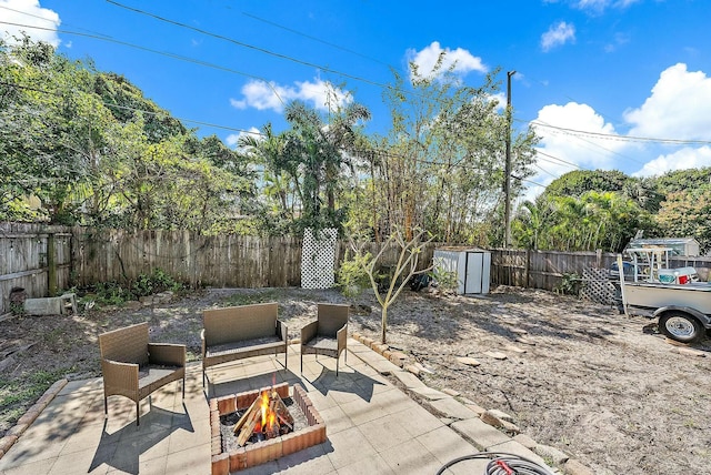 view of patio / terrace with a storage shed and a fire pit