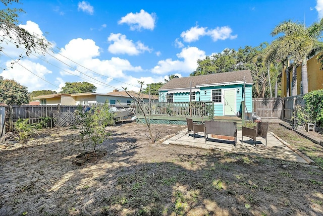 back of house with a patio area, an outdoor structure, and a deck