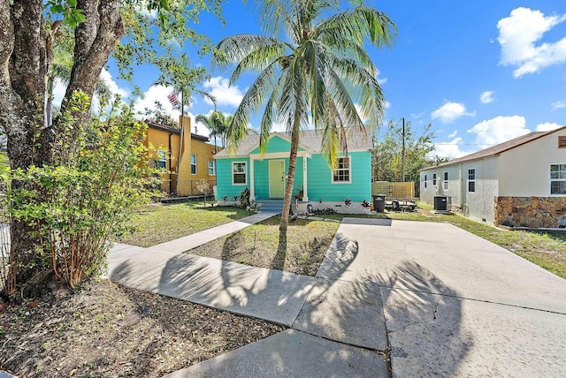 view of front of house featuring a front lawn and central air condition unit