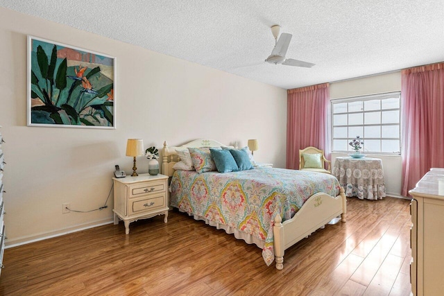 bedroom with wood-type flooring, ceiling fan, and a textured ceiling