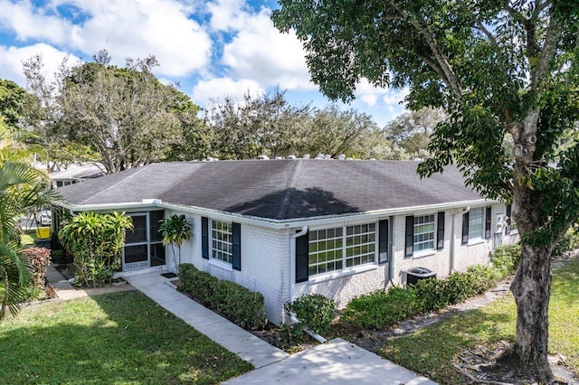 ranch-style house with central AC unit and a front lawn