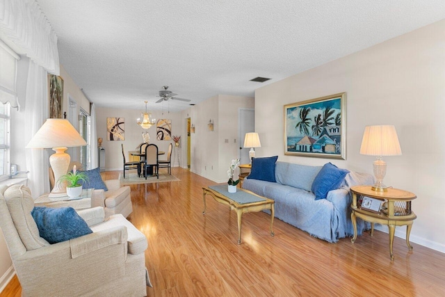 living room with hardwood / wood-style flooring, an inviting chandelier, and a textured ceiling