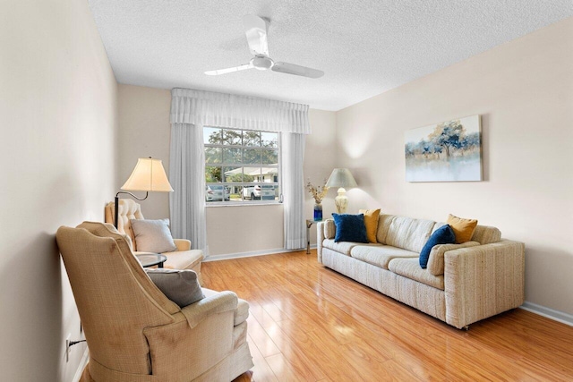 living room featuring hardwood / wood-style floors, a textured ceiling, and ceiling fan