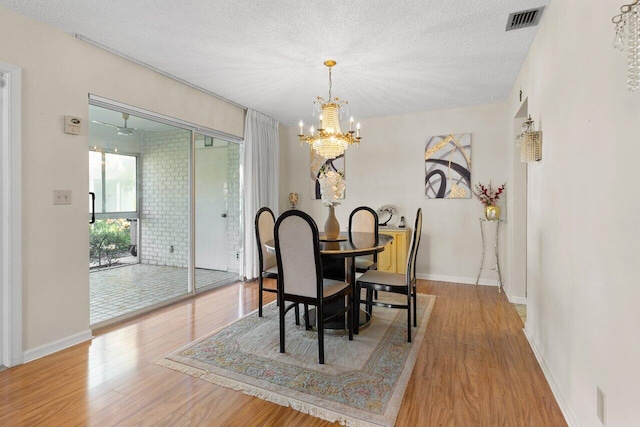 dining space featuring a chandelier, hardwood / wood-style floors, and a textured ceiling