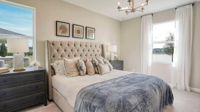 carpeted bedroom featuring multiple windows and an inviting chandelier