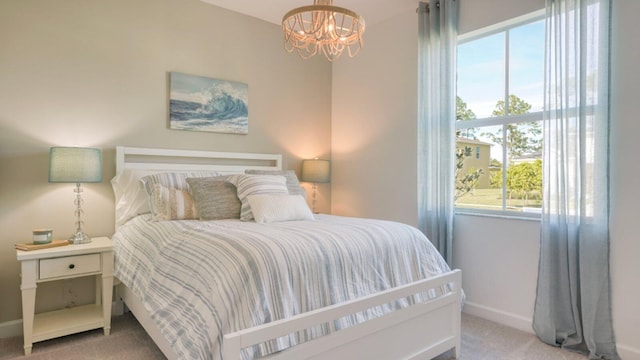 bedroom with light colored carpet and a notable chandelier