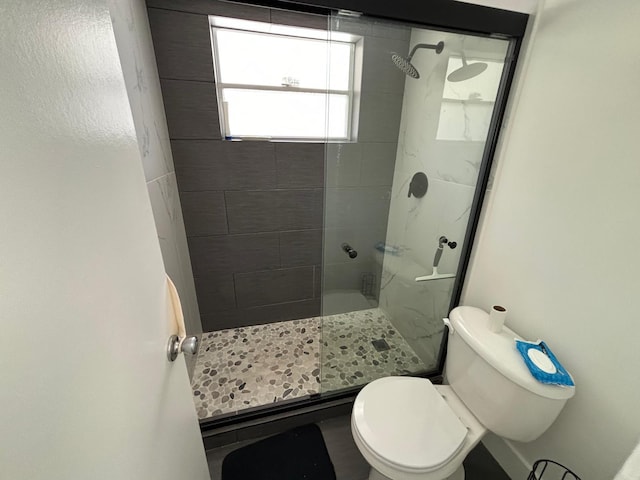 bathroom featuring walk in shower and toilet