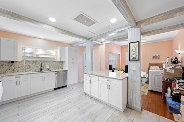 kitchen with white cabinets, washer / dryer, sink, and dishwasher