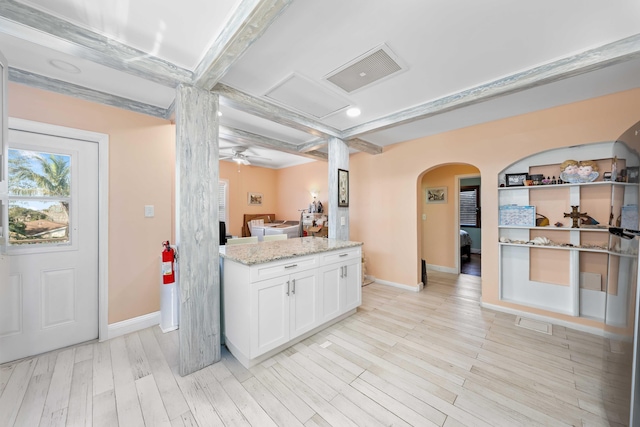 kitchen featuring coffered ceiling, white cabinetry, ceiling fan, light stone countertops, and light hardwood / wood-style floors