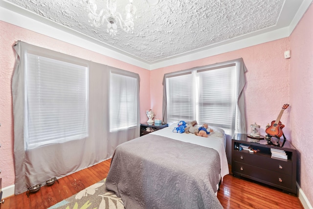 bedroom featuring wood-type flooring and a textured ceiling