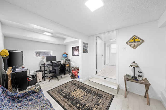 office area featuring a textured ceiling and light hardwood / wood-style flooring