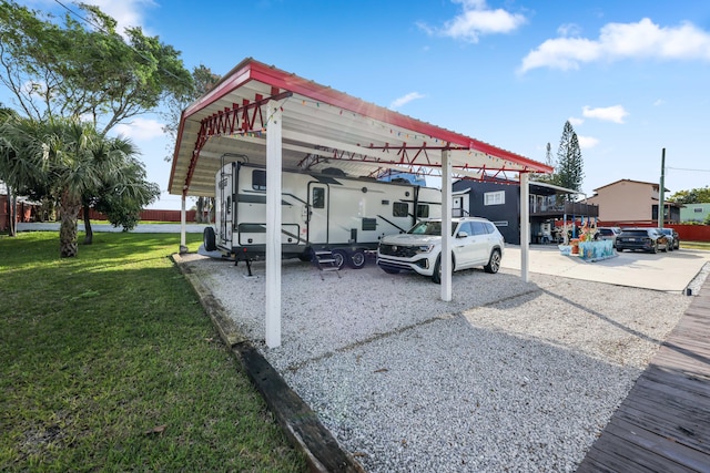 view of parking / parking lot featuring a carport and a yard