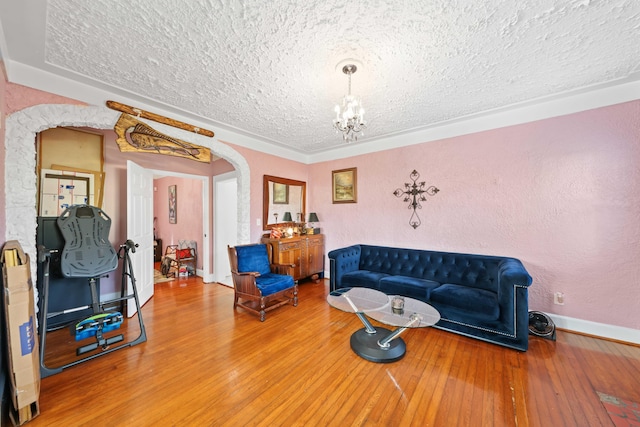 living room with hardwood / wood-style flooring, an inviting chandelier, and a textured ceiling