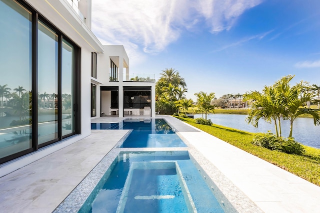 view of swimming pool with a patio, a water view, and an in ground hot tub