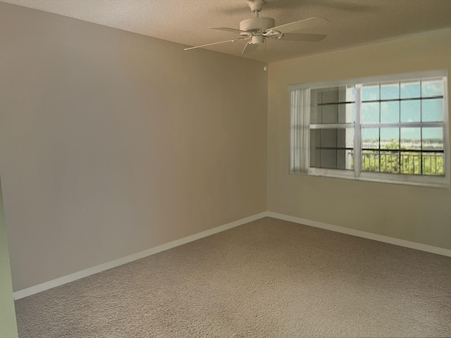 carpeted empty room featuring a ceiling fan, a textured ceiling, and baseboards