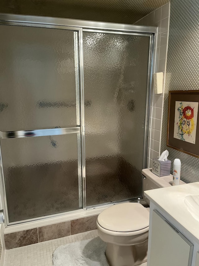 full bathroom featuring tile patterned floors, a stall shower, toilet, wallpapered walls, and vanity
