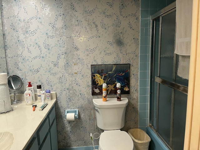 full bathroom with wallpapered walls, an enclosed shower, toilet, and vanity