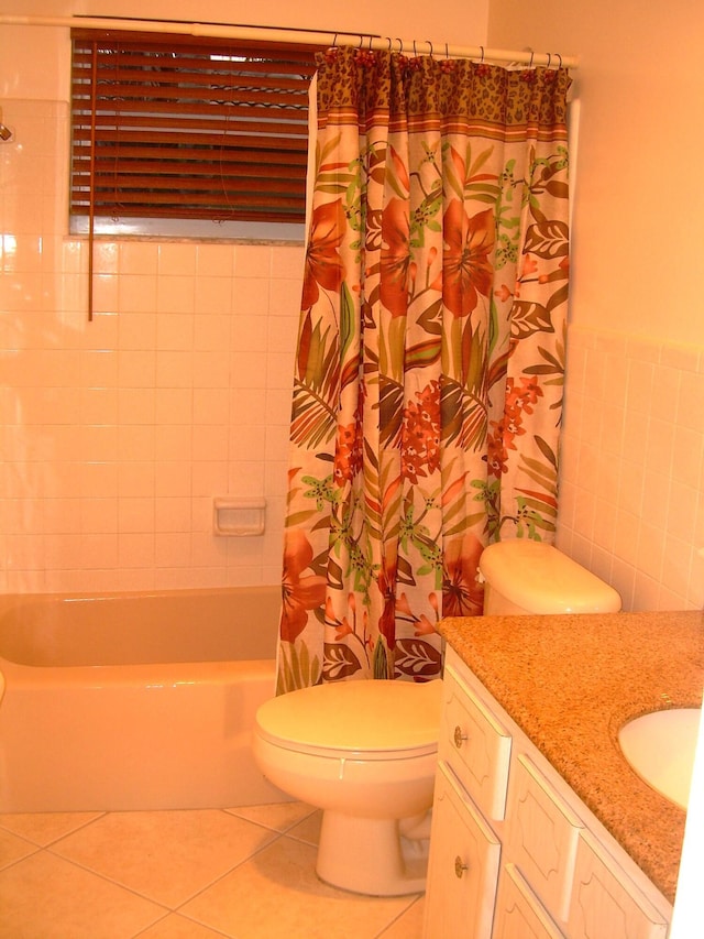 full bathroom featuring shower / tub combo with curtain, tile walls, vanity, toilet, and tile patterned floors