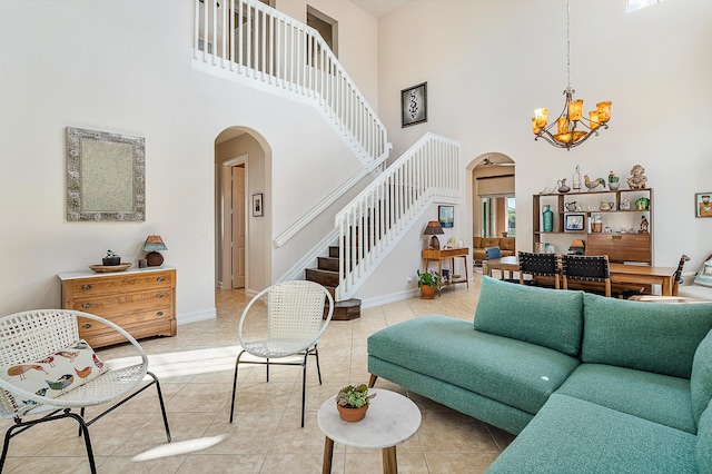 tiled living room featuring an inviting chandelier and a towering ceiling