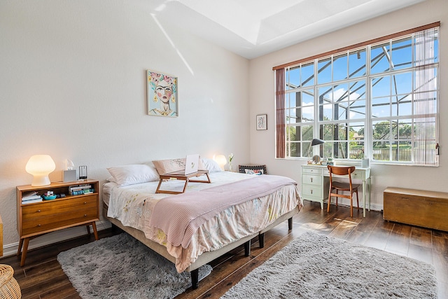 bedroom with dark hardwood / wood-style flooring