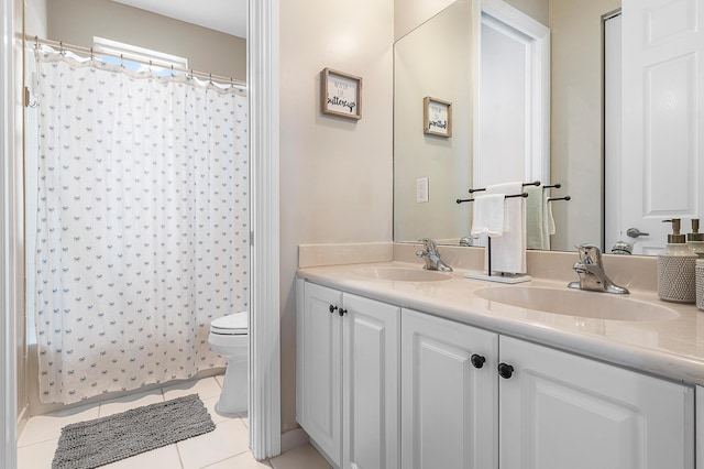 bathroom with tile patterned flooring, vanity, and toilet