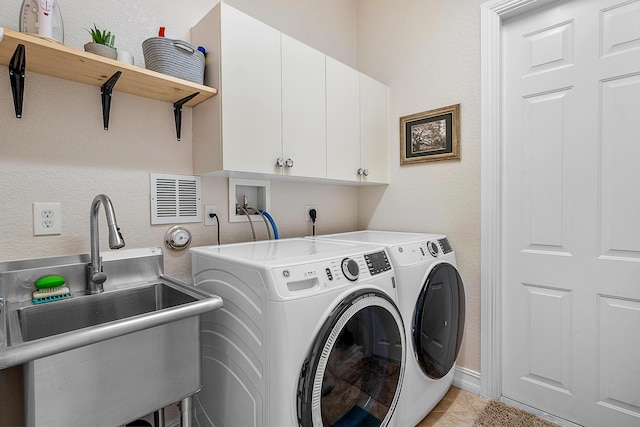 clothes washing area with independent washer and dryer, sink, cabinets, and light tile patterned floors