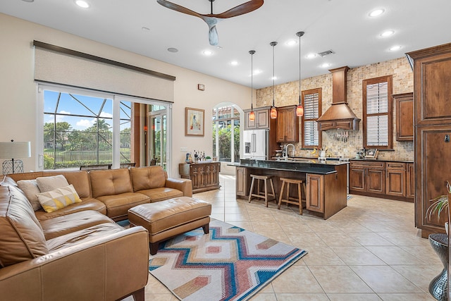 living room featuring sink, ceiling fan, and light tile patterned flooring