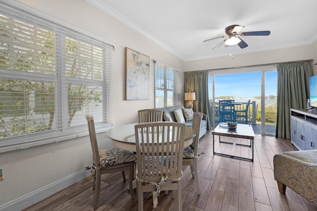 dining room featuring baseboards, ceiling fan, wood finished floors, and crown molding