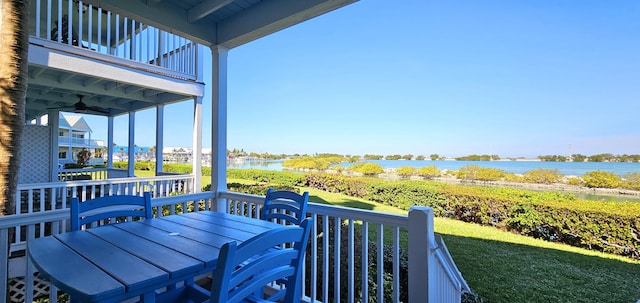 balcony with outdoor dining area and a water view
