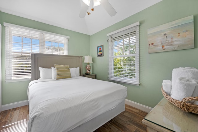 bedroom featuring baseboards, lofted ceiling, wood finished floors, and a ceiling fan