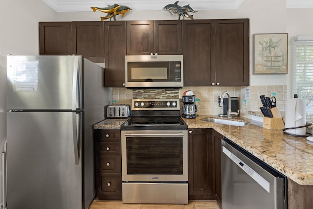 kitchen featuring a sink, dark brown cabinetry, decorative backsplash, and appliances with stainless steel finishes