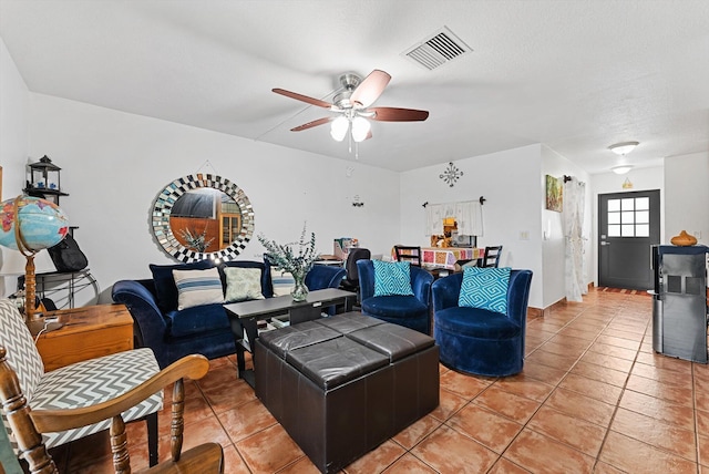 living area with a ceiling fan, visible vents, and light tile patterned floors