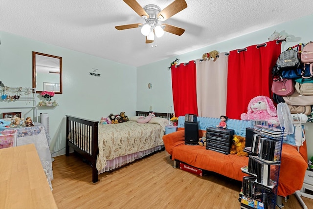 bedroom featuring ceiling fan, wood-type flooring, and a textured ceiling