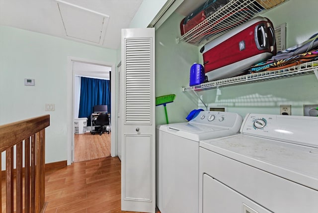laundry room with baseboards, laundry area, light wood-type flooring, and washer and clothes dryer