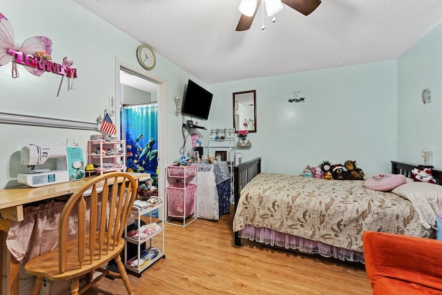 bedroom with ceiling fan, a textured ceiling, and light wood-type flooring