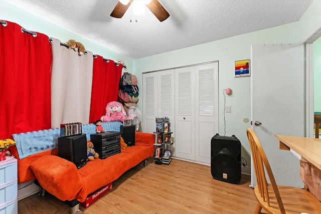 bedroom featuring ceiling fan, hardwood / wood-style floors, a closet, and a textured ceiling