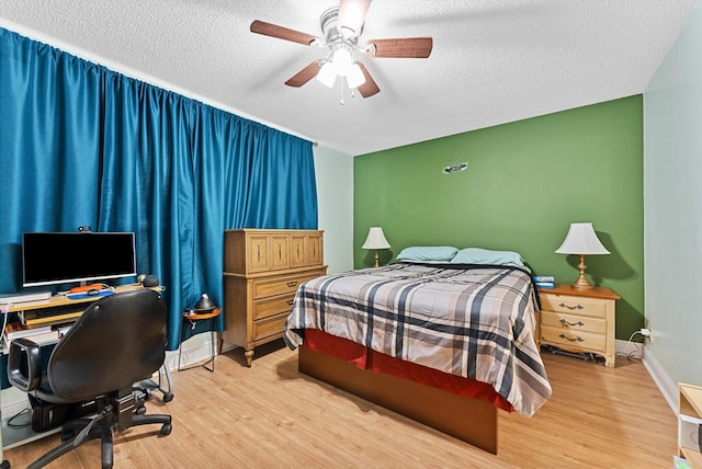 bedroom featuring ceiling fan, a textured ceiling, and light wood-type flooring