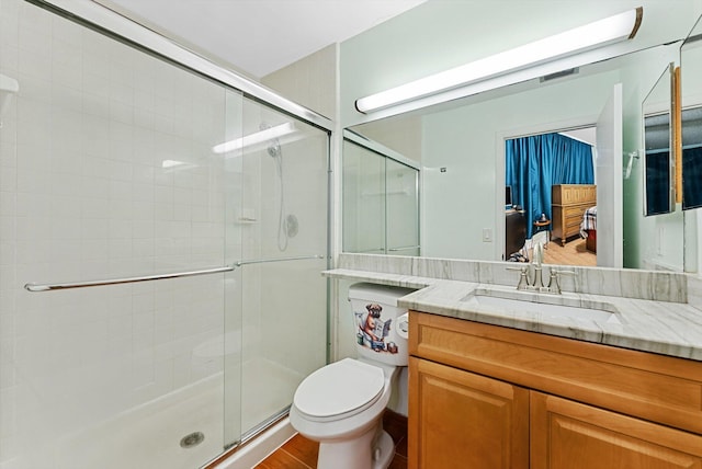 bathroom with vanity, hardwood / wood-style flooring, toilet, and walk in shower