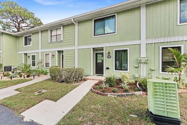 view of property with a front yard and central air condition unit