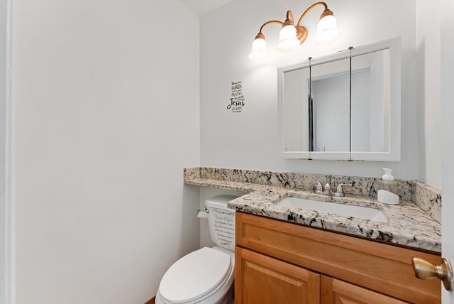 half bathroom with vanity and toilet