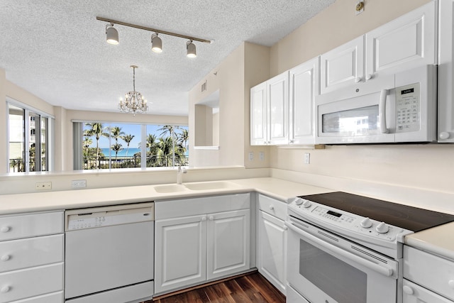 1660 S A1A Unit 222, Jupiter, FL 33477 - kitchen with white appliances, a sink, a chandelier, white cabinetry, and a textured ceiling