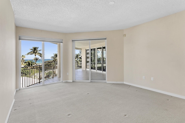 1660 S A1A Unit 222, Jupiter, FL 33477 - spare room with light carpet, baseboards, and a textured ceiling