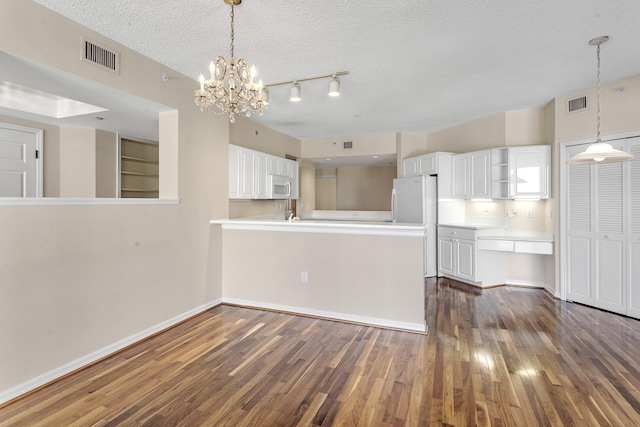 1660 S A1A Unit 222, Jupiter, FL 33477 - kitchen with white microwave, dark wood-type flooring, white cabinets, open shelves, and a textured ceiling