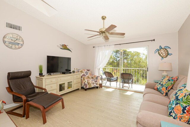 living room featuring ceiling fan, lofted ceiling, and light wood-type flooring